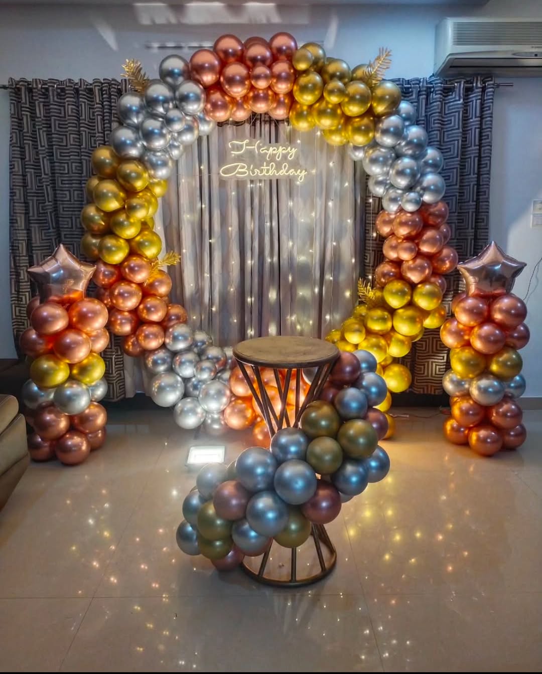 A birthday celebration decorated with a balloon arch and Happy Birthday sign